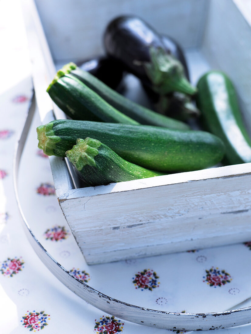 Close-up of zucchini and eggplant in white box