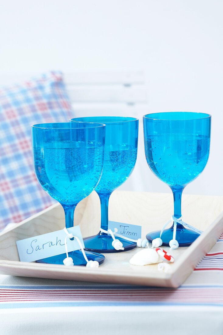 blaue Gläser mit Namensschild auf Tablett