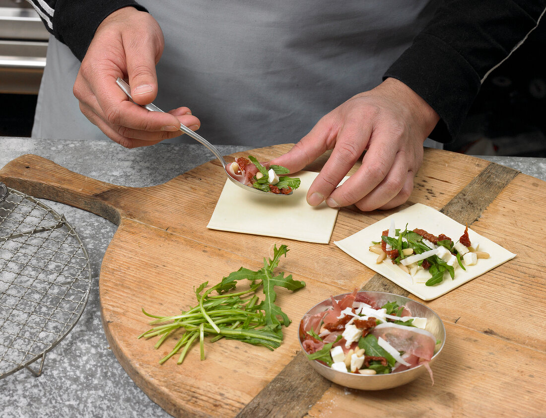 Stuffing ham and arugula in dough for preparation of puff pastry, step 1