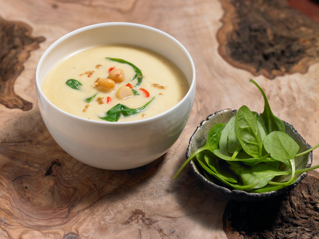 Spinach soup with chickpea and spinach leaves in bowls