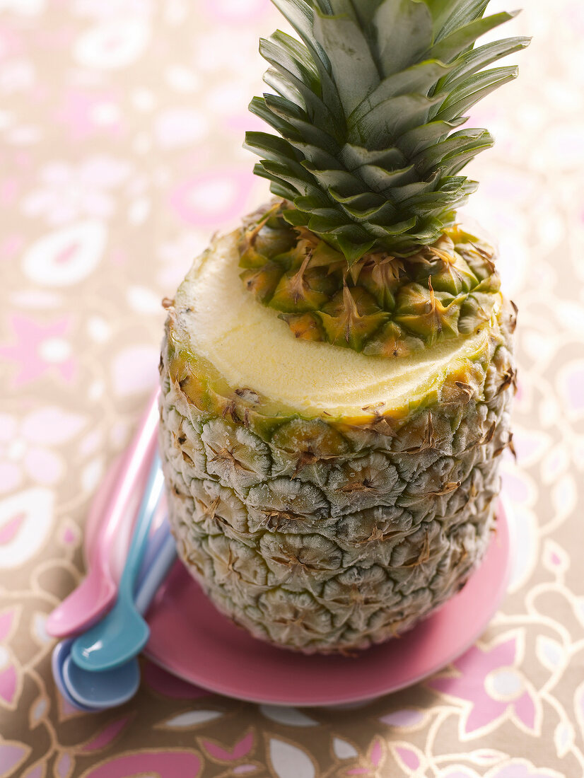 Pina colada ice-cream in whole pineapple on pink plate