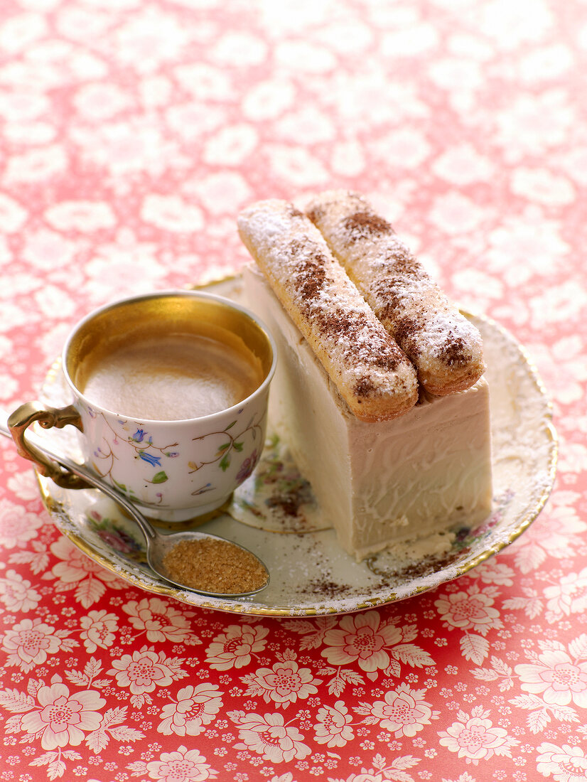 Tiramisu parfait with ladyfingers and cup of coffee on plate