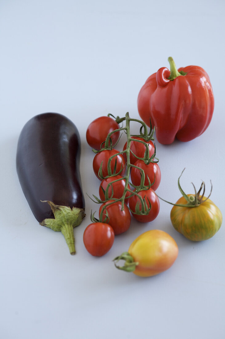 Eggplant, wine tomatoes and peppers on white background