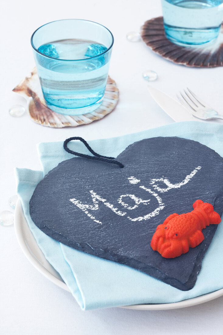 Slate heart as placeholder with marzipan lobster toy