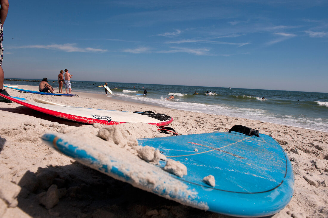 Man holding surfboard at Long Beach in New York, USA