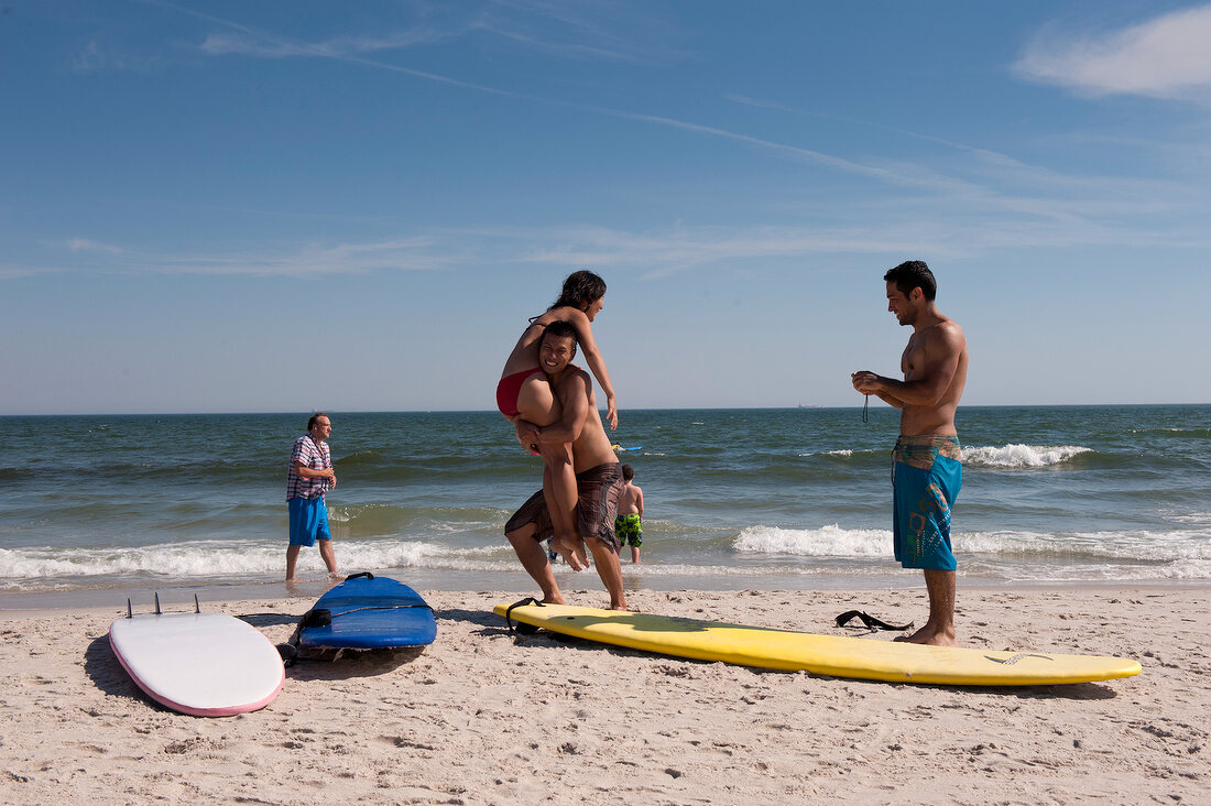 Man holding surfboard at Long Beach in New York, USA