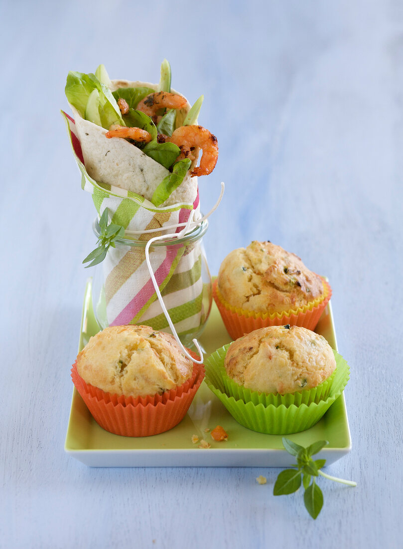Wrap with pesto, shrimp and vegetables with muffins on square plate