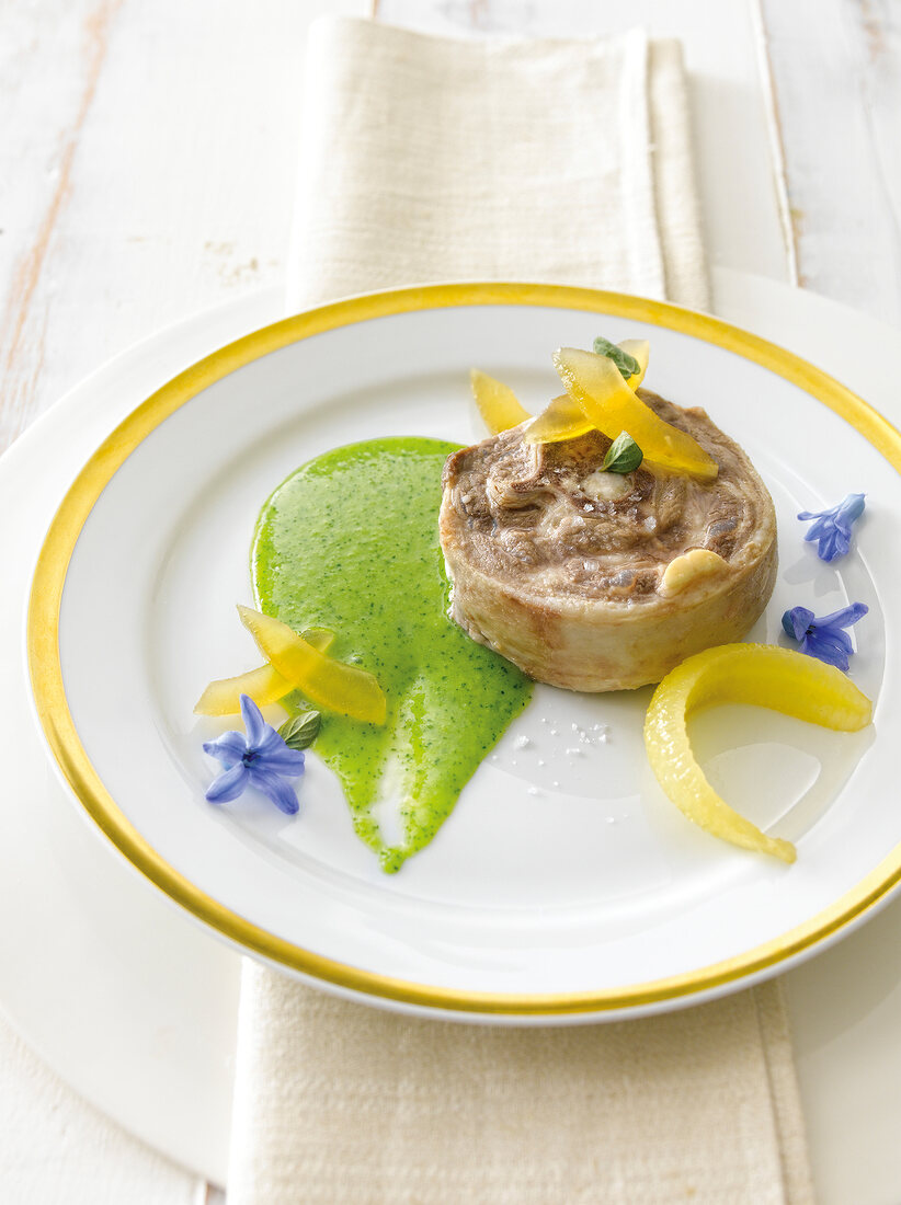 Cucumber and lemon compote with borage and lamb on plate