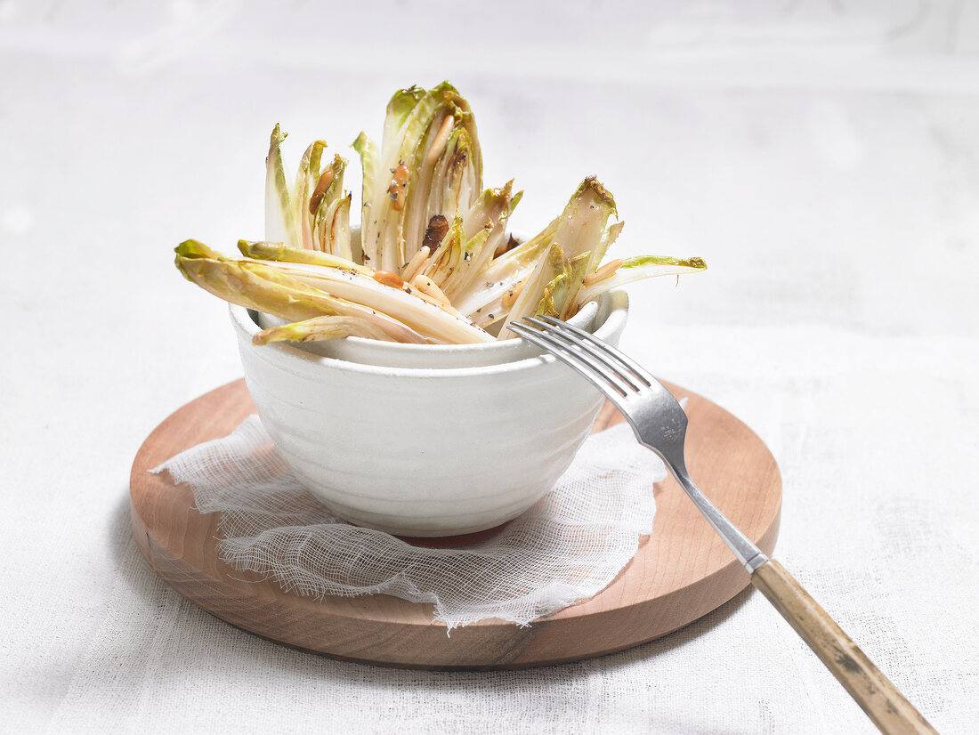 Chicory with pine nuts in bowl