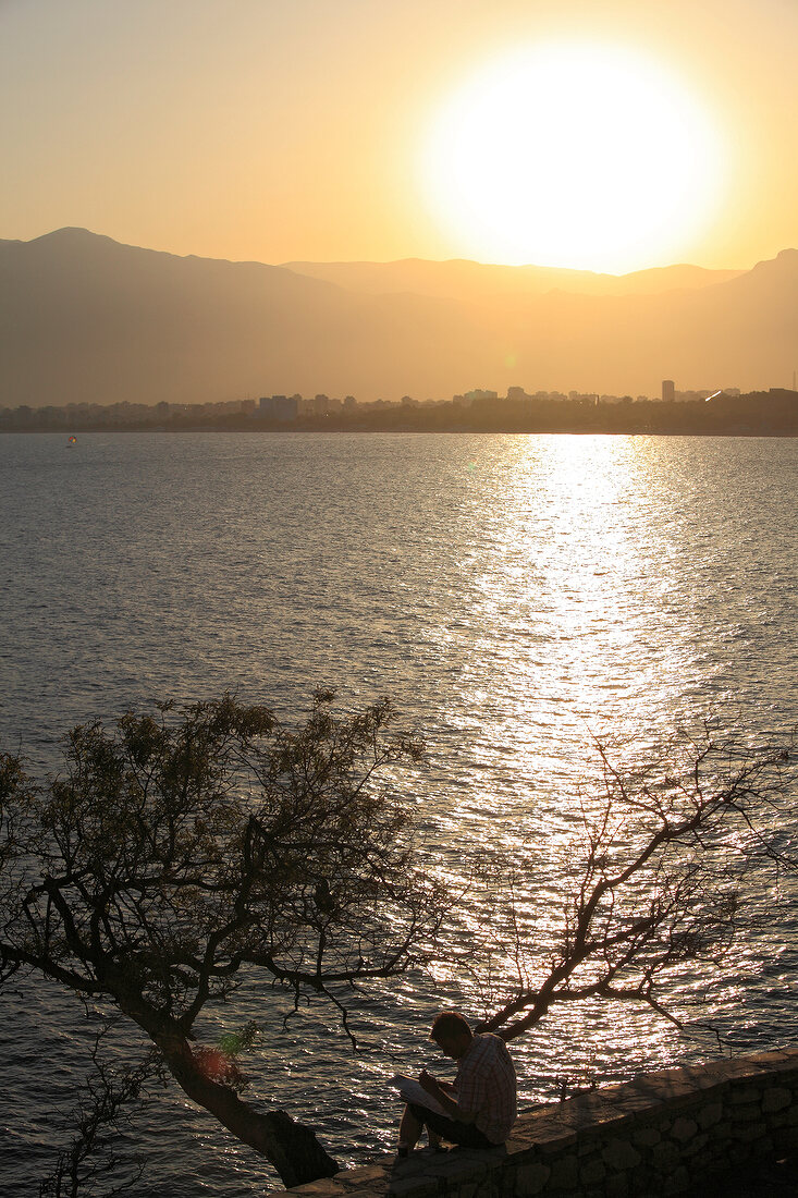 View of man sitting near sea at sunset in Antalya, Turkey