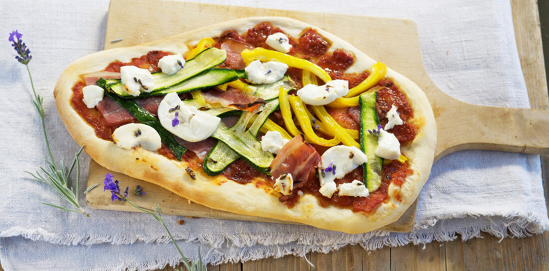 Ratatouille pizza with goat cheese on wooden board