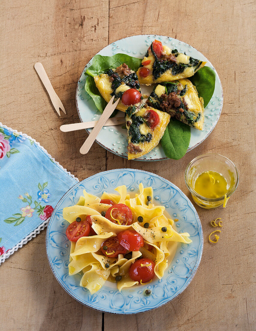 Conchiglie pasta with tomato and spinach omelette on plates
