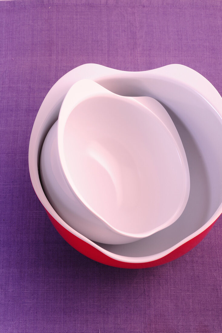 Mixing bowls one inside the other on purple background