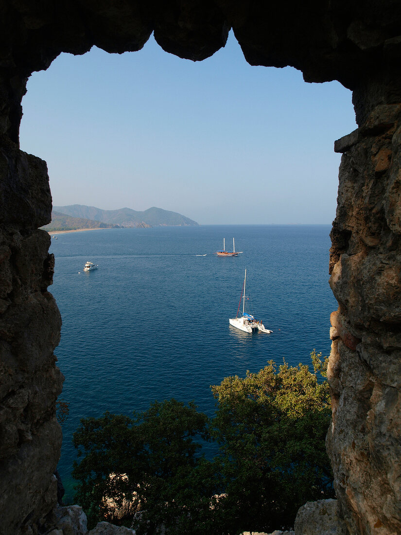 View of boat in sea from ruined city of Olympos, Lycia, Turkey