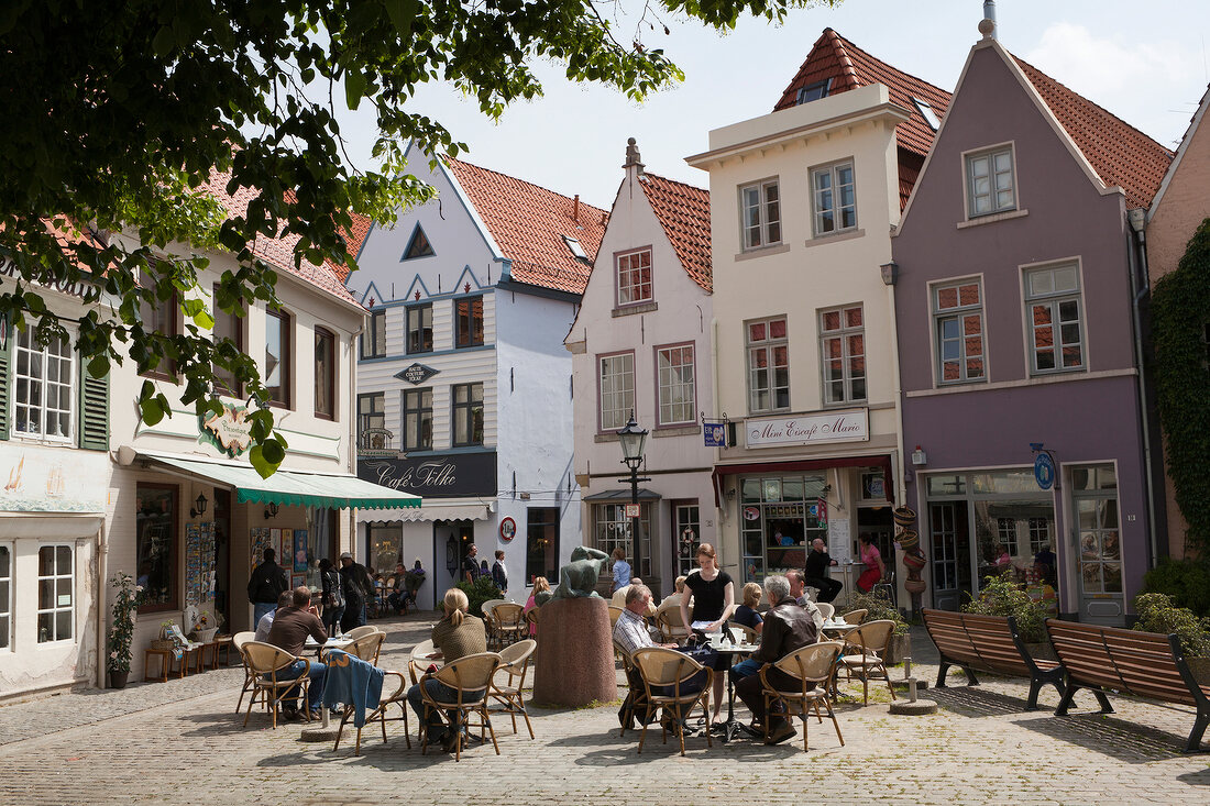 People sitting in cafe at Schnoorviertel street in Bremen, Germany