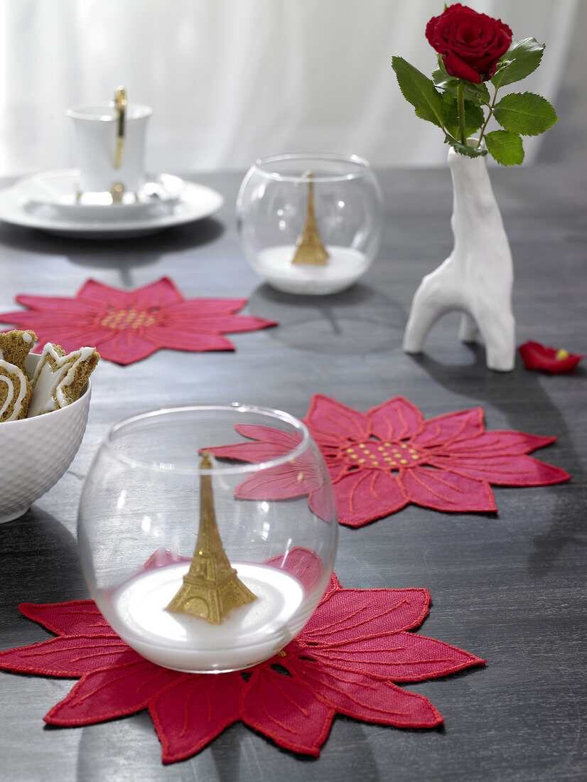 Eiffel tower model in glass with embroidered poinsettias trivet on table