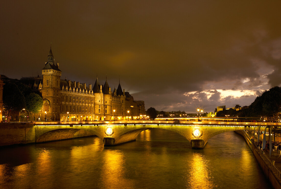 Illuminated Pont au Change bridge at evening in Paris, France