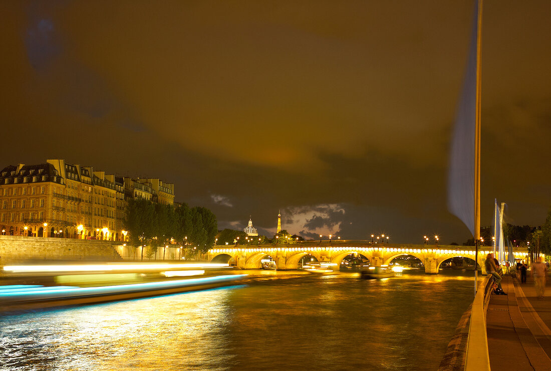 Illuminated Pont au Change bridge at evening in Paris, France