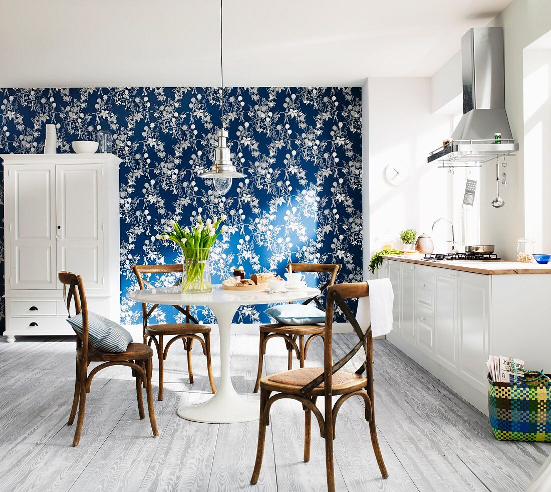 Moderne weiße Landhausküche mit blau- weiß tapezierter Wand