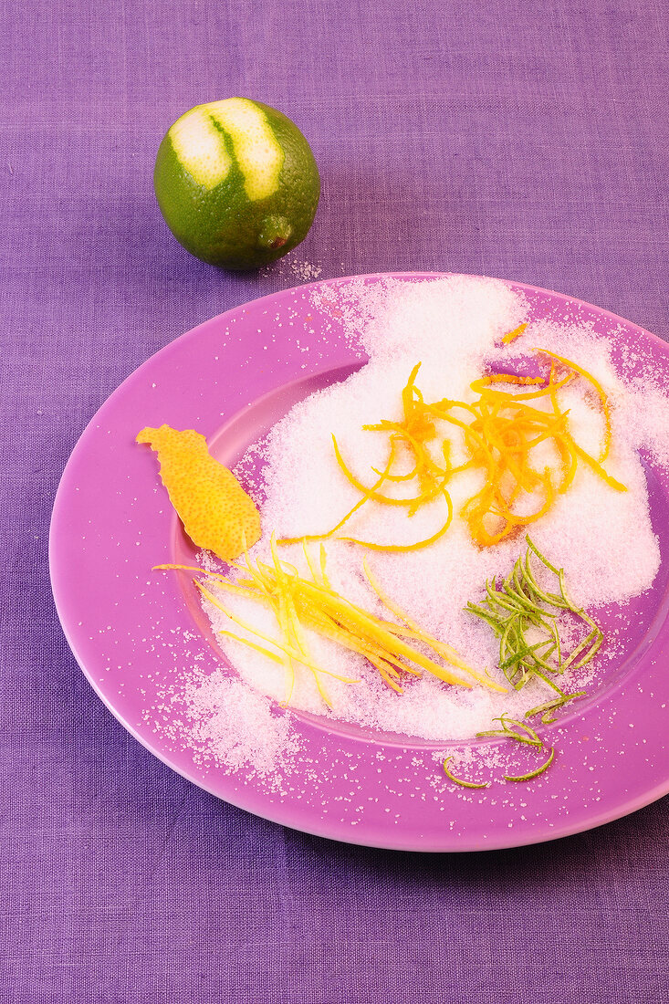 Citrus skins with icing sugar on plate for preparation of desserts
