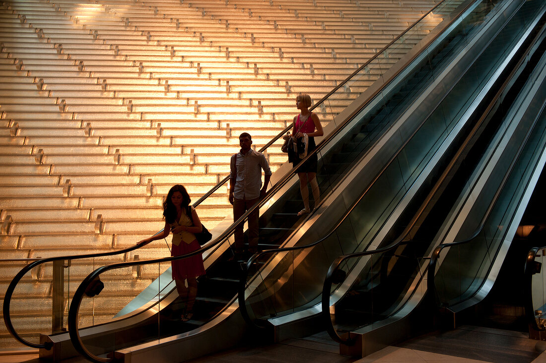People on escalator in an office building in New York, USA