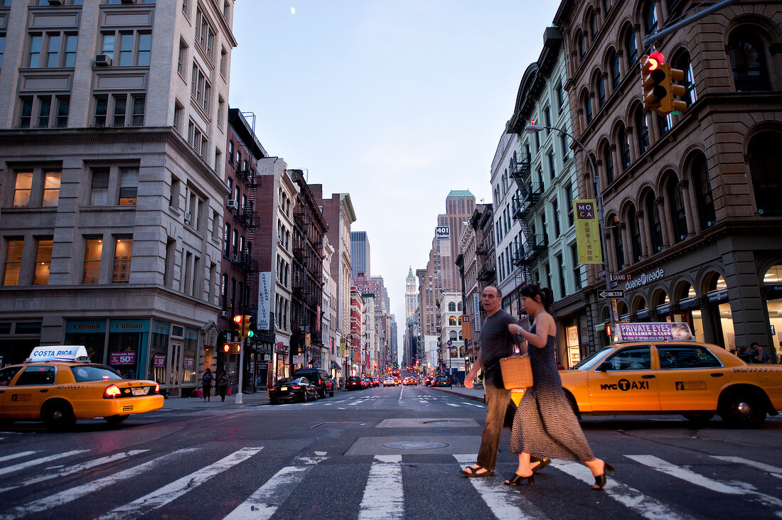 Couple walking across zebra crossing in Broadway, SoHo, Manhattan, New York, USA