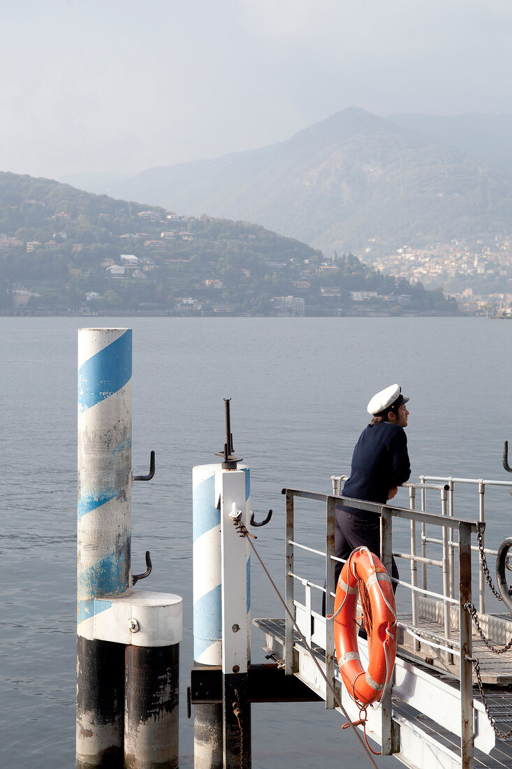 Sailor standing on boat dock and looking at Lake Como in Como, Lombardy, Italy