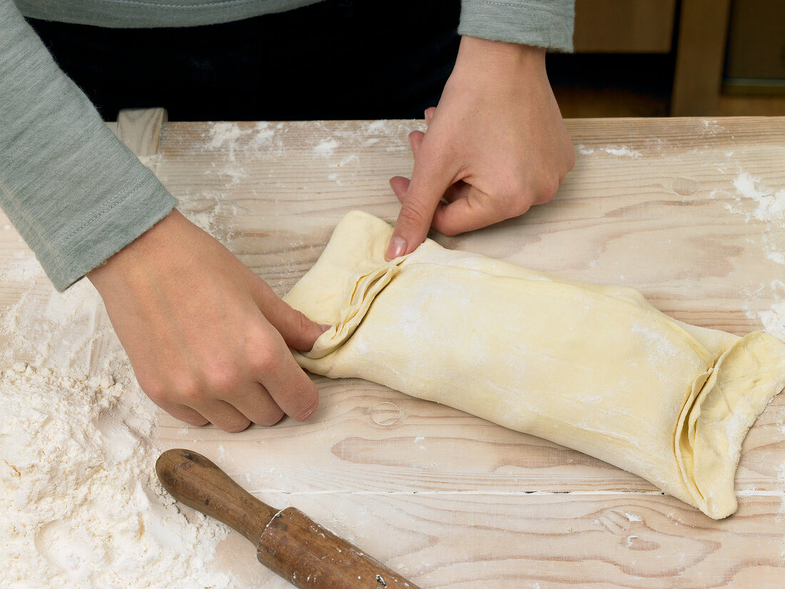 Hand squeezing filled dough for preparation of puff pastry, step 2
