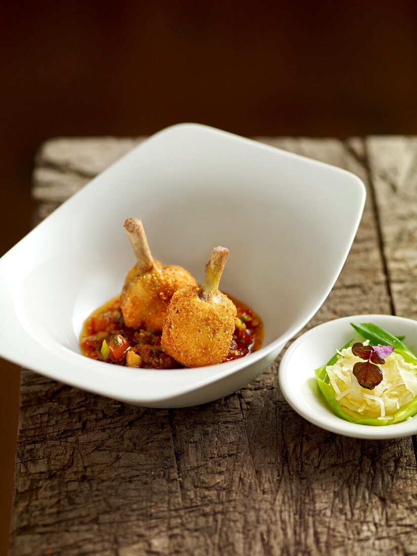 Chicken wings with chilli sauce and cabbage in serving bowl