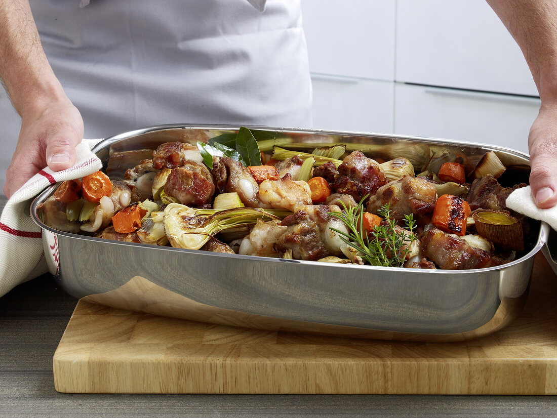 Vegetables and bones in baking dish for roasting