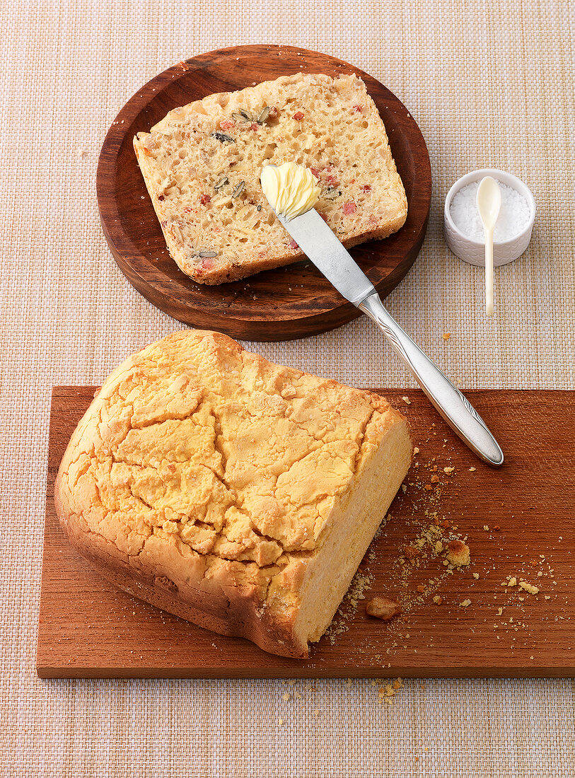 Cheese bread and yellow corn bread with ham on wooden platter