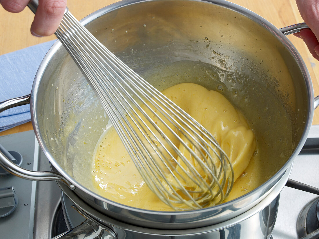 Whisking egg yolk-sugar mixture in pan for preparation of zabaglione, step 3