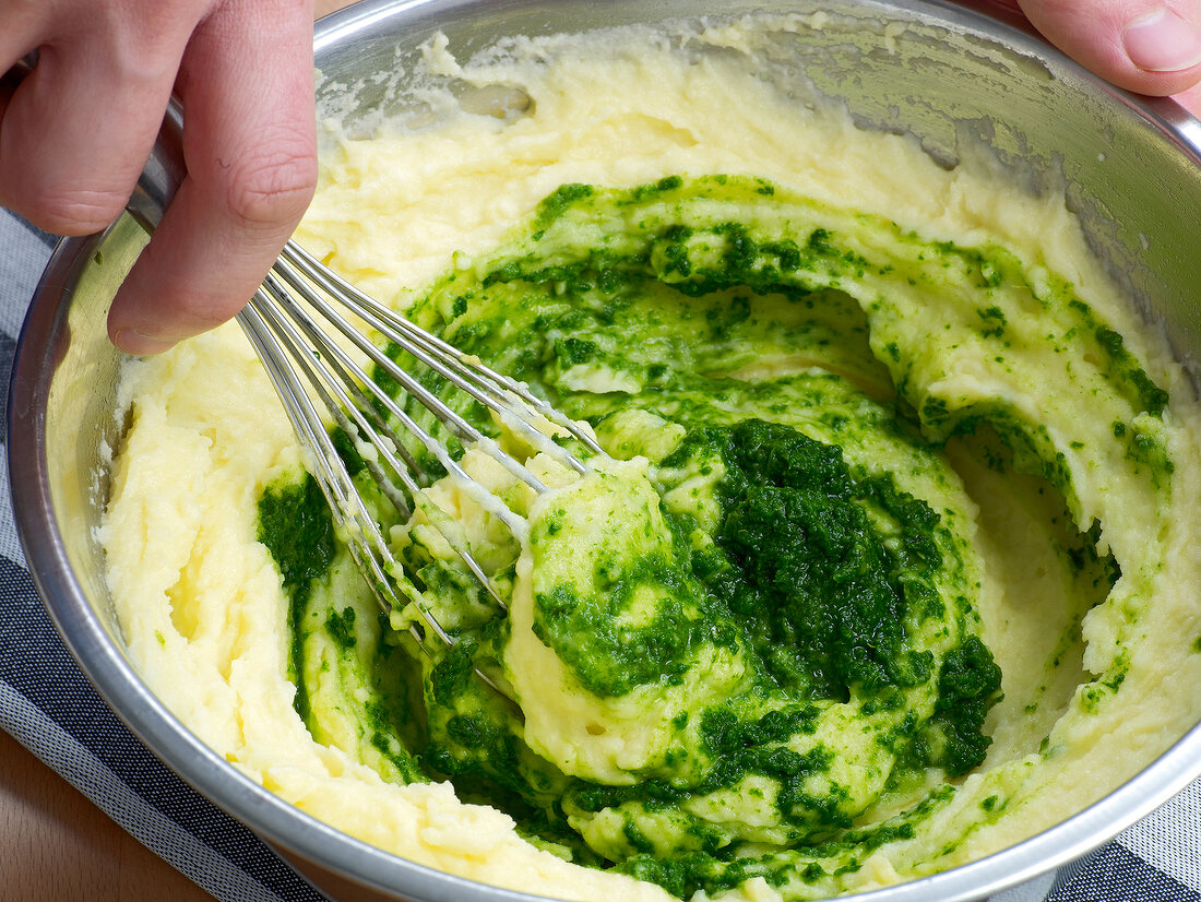 Adding herb puree in mixture for colour while preparing sauce