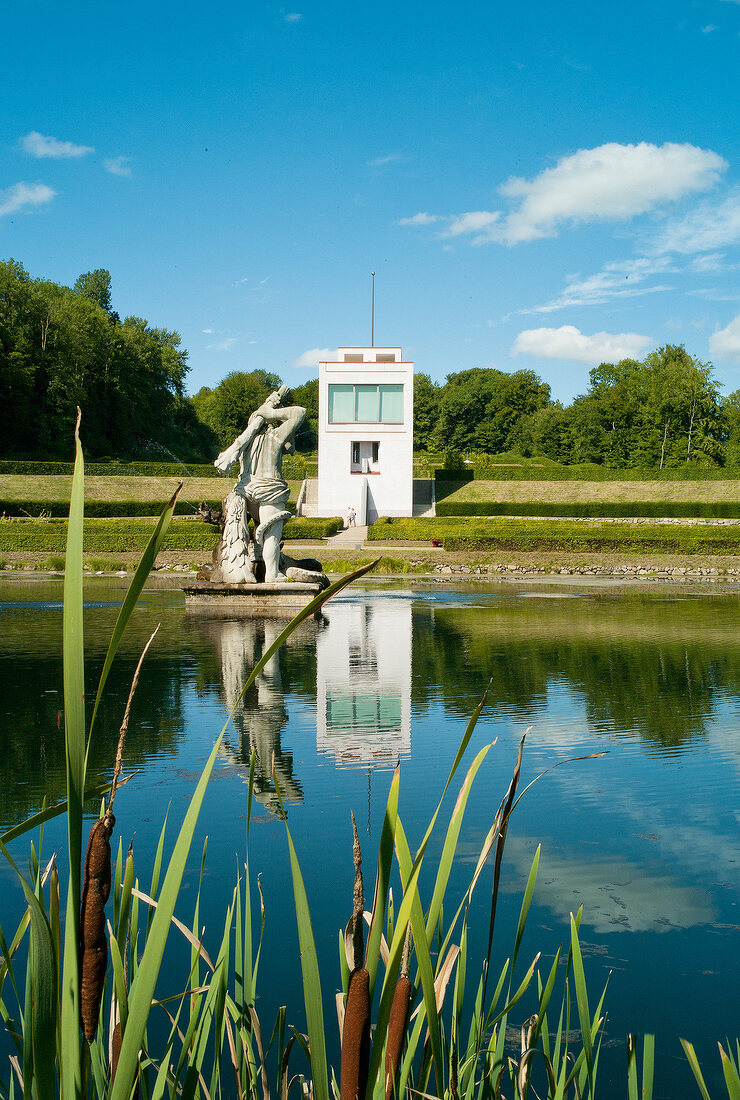 View of Schleswig Gottorp Castle Park with statue reflection in water, Baltic Coast