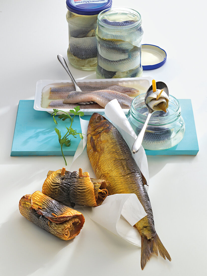 Various raw fish in jars, baking paper and plastic container