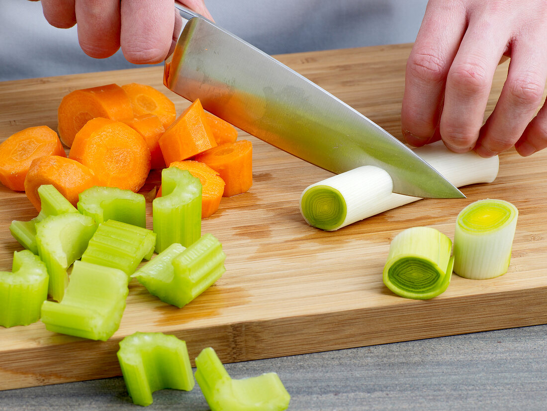 Hand cutting vegetables for preparation of chicken broth, step 2