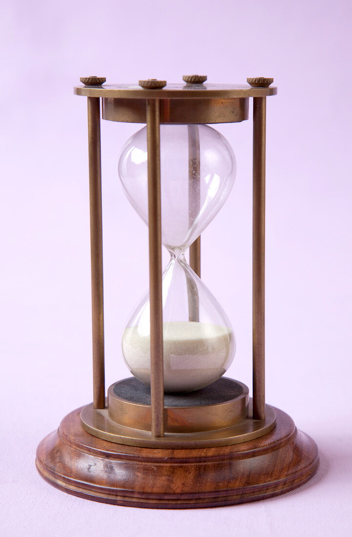Wooden hourglass on pink background