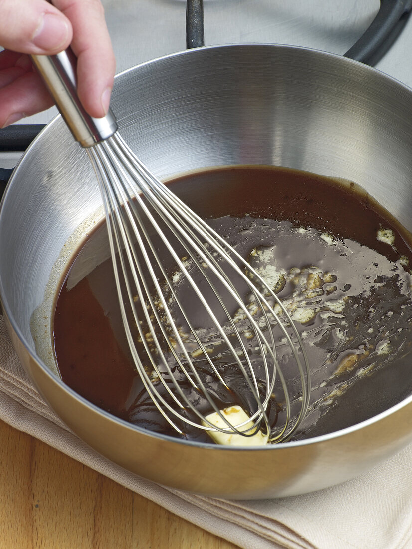 Adding butter in sauce and whisking in bowl, step 2