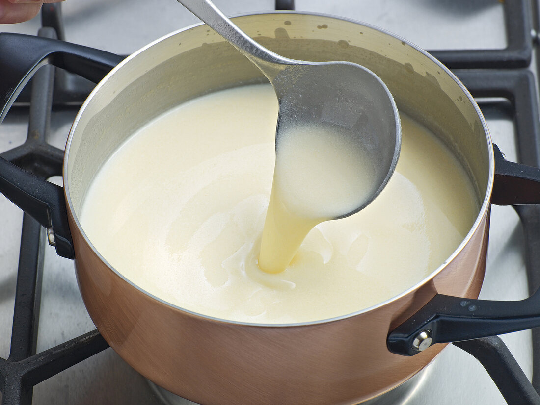 Stirring creme fraiche with ladle in pan, step 2