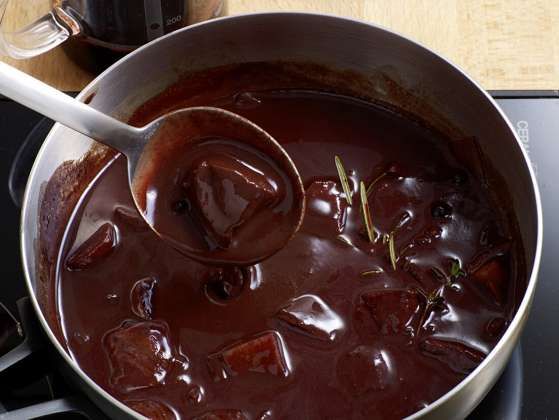 Close-up of mixture being stirred with ladle in pan, step 2