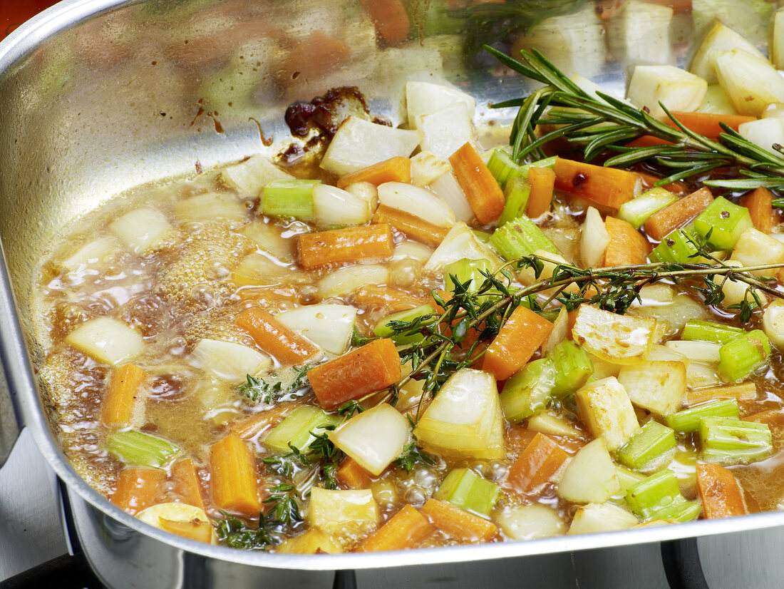 Close-up of vegetables being boiled in pan for preparation of bratenjus, step 3