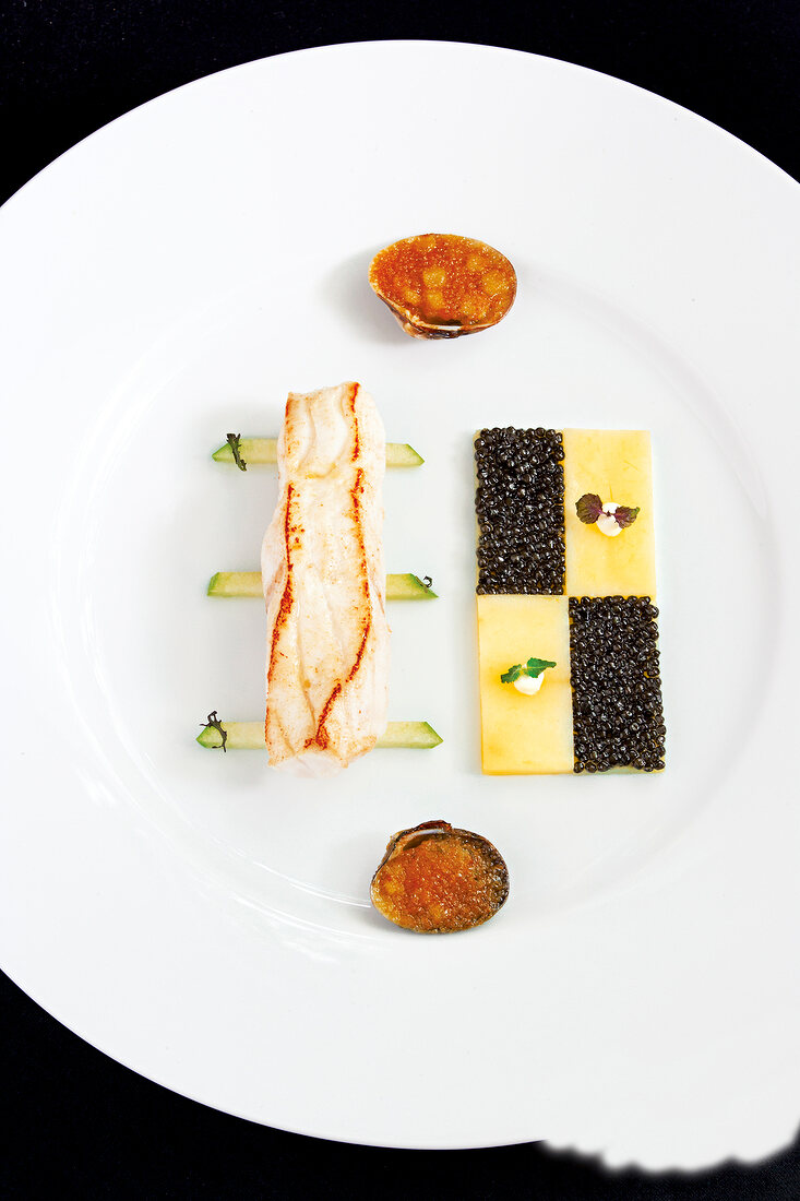 Turbot with potatoes and caviar on plate