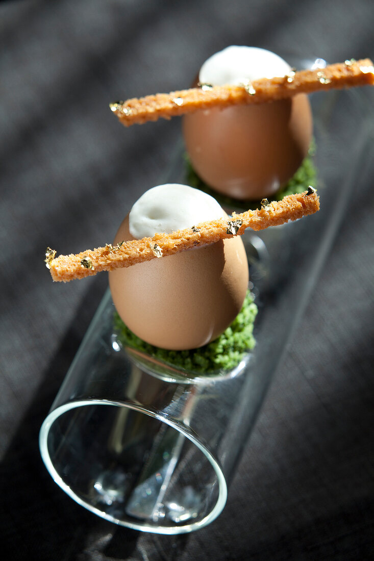Eggs with artichoke cream and bread sticks on glass