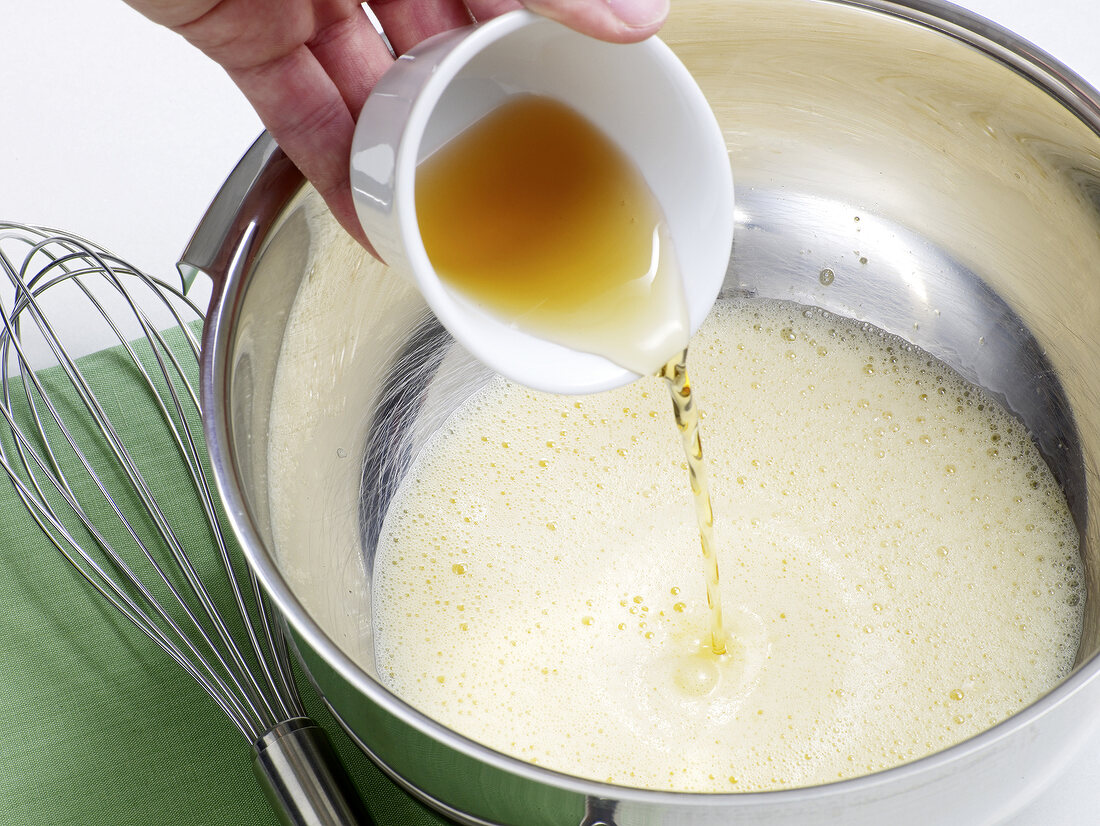 Wine being poured in mixture for preparation of champagne sabayon, step 2