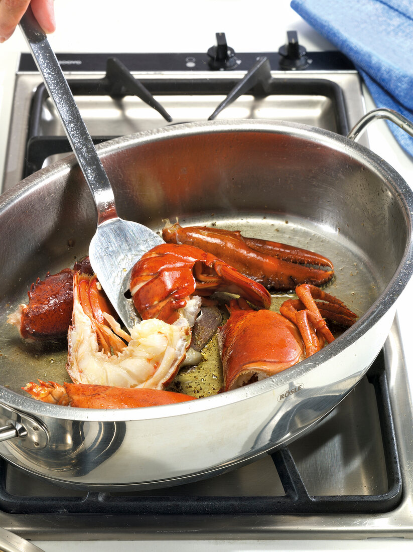 Close-up of lobster pieces being roasted in pan