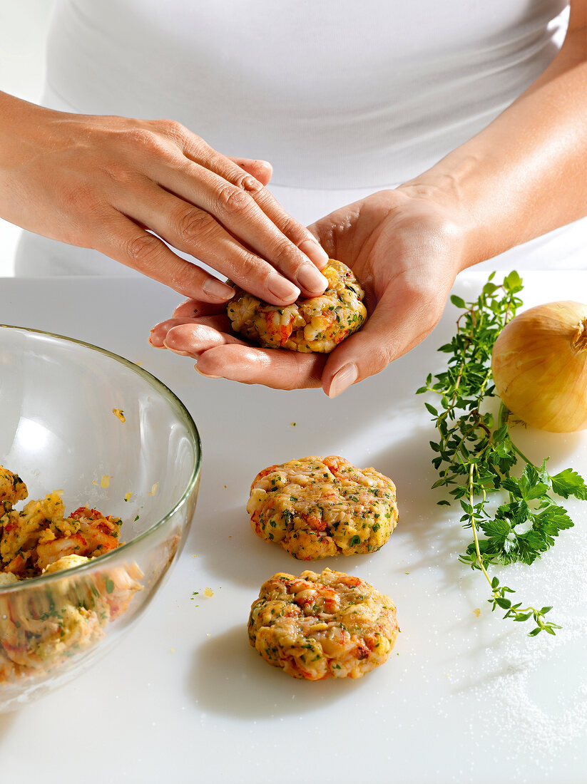 Close-up of hand making round shaped crab cakes