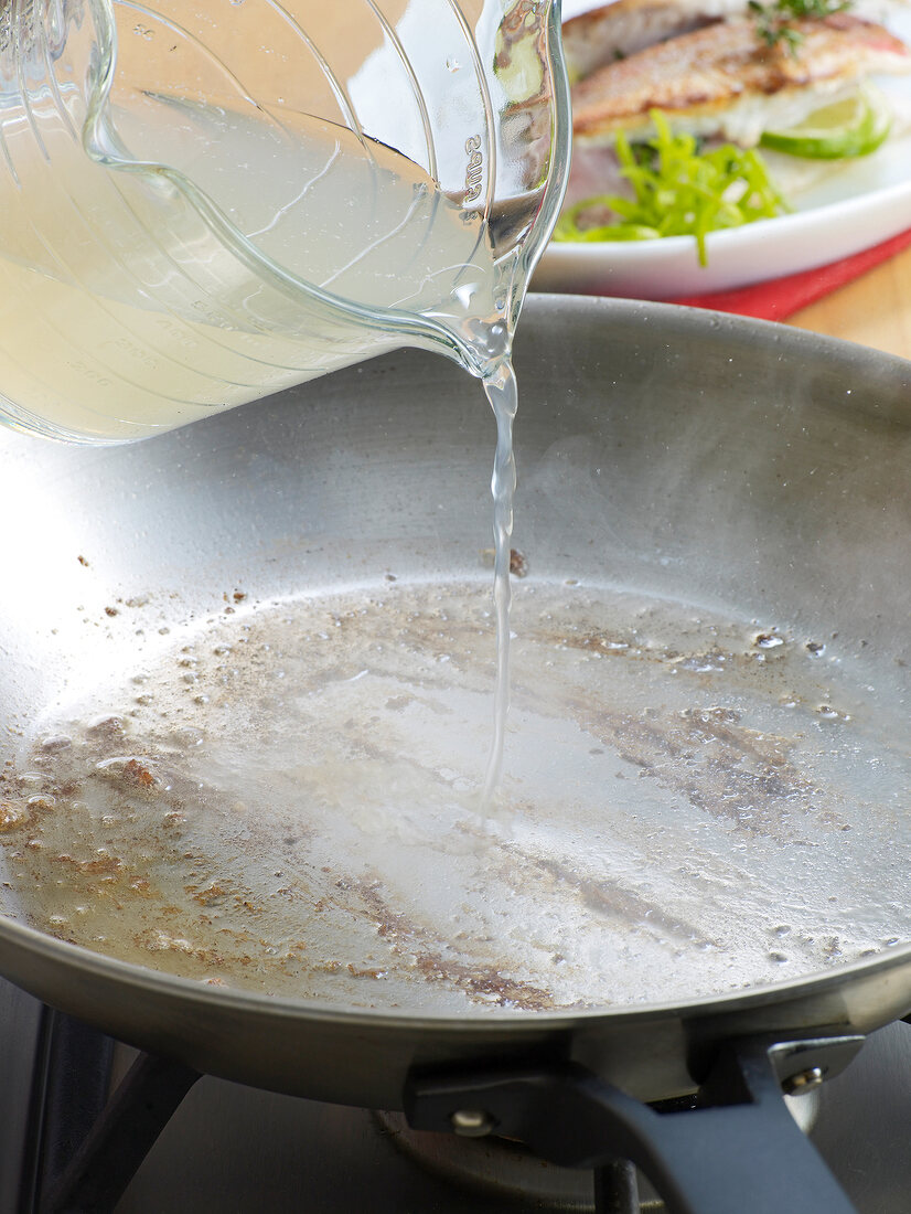 Close-up of lime juice being poured in saucepan