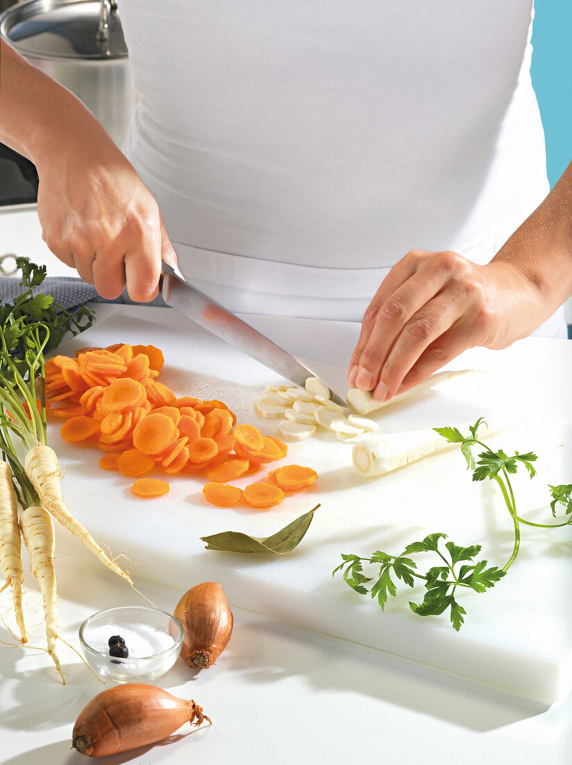 Vegetables being chopped in small pieces on white board