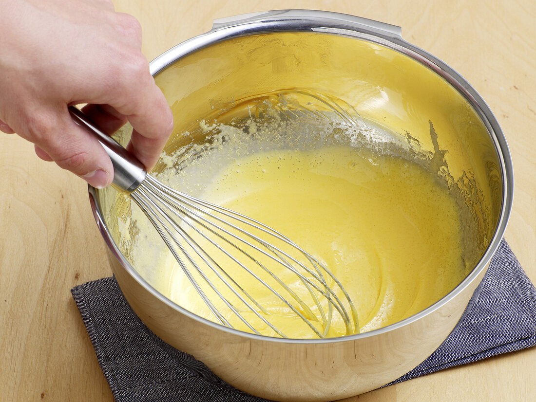 Butter being whisked in bowl for preparation of vanilla sauce, step 1