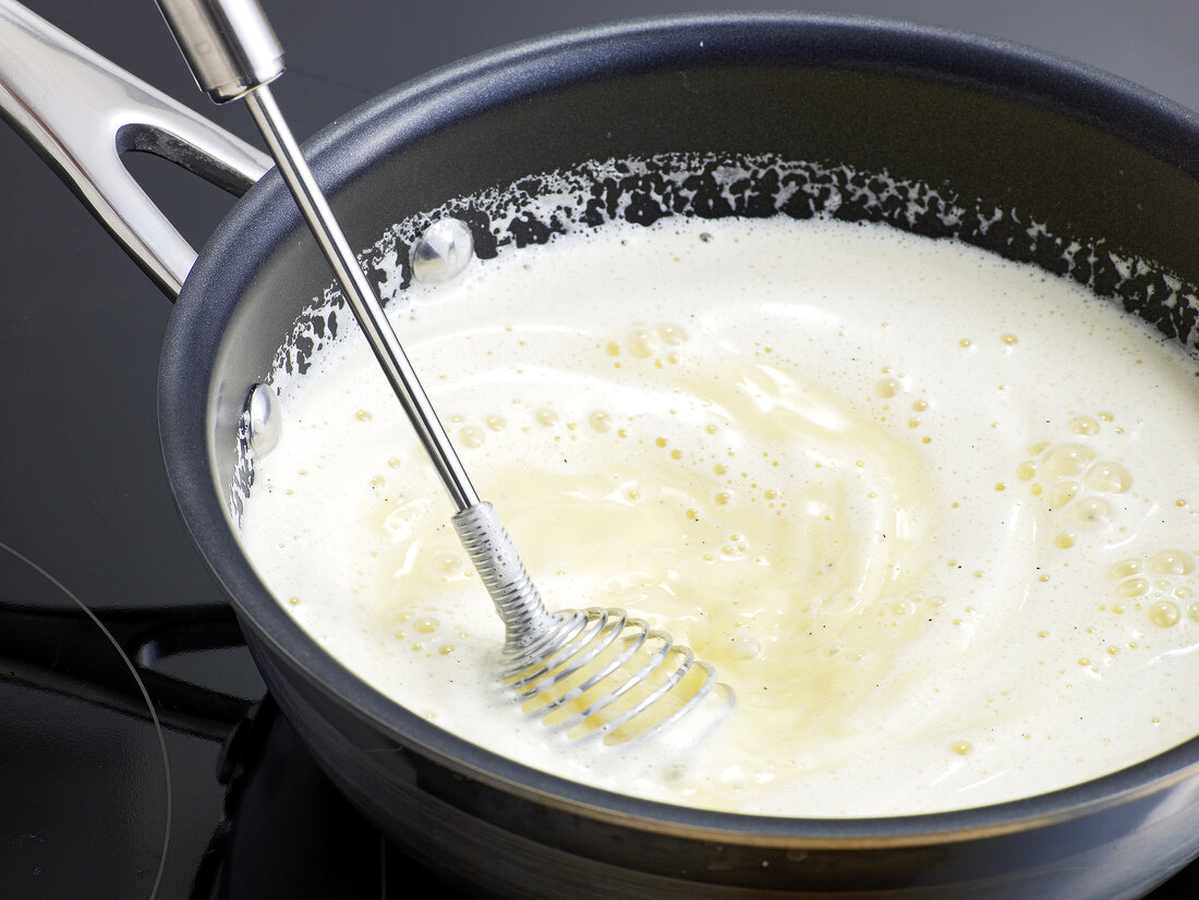 Close-up of mixture of milk, vanilla and butter being mixed with whisk, step 4